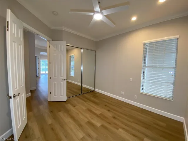 Unfurnished bedroom featuring ornamental molding, light wood-type flooring, a ceiling fan, and a closet