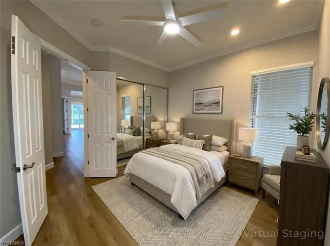 Bedroom with ornamental molding, wood finished floors, a ceiling fan, and a closet
