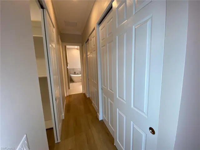 Hall featuring wood finished floors and crown molding