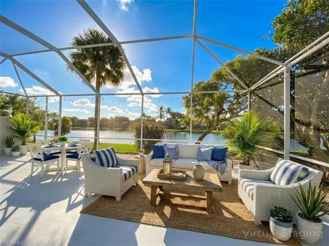 View of patio with a sunroom, an outdoor living space, a water view, and glass enclosure