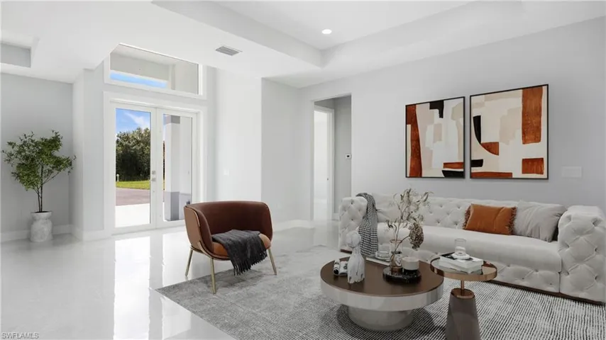 Living room with a tray ceiling, french doors, and recessed lighting