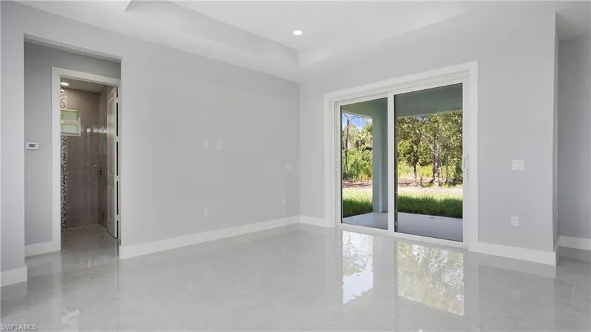 Unfurnished room with plenty of natural light, a raised ceiling, and recessed lighting