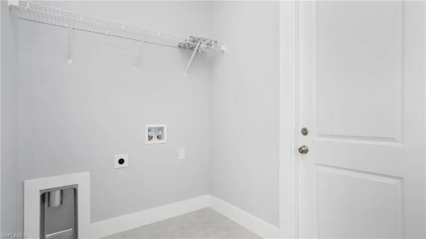 Laundry room featuring hookup for an electric dryer, hookup for a washing machine, and light tile patterned flooring