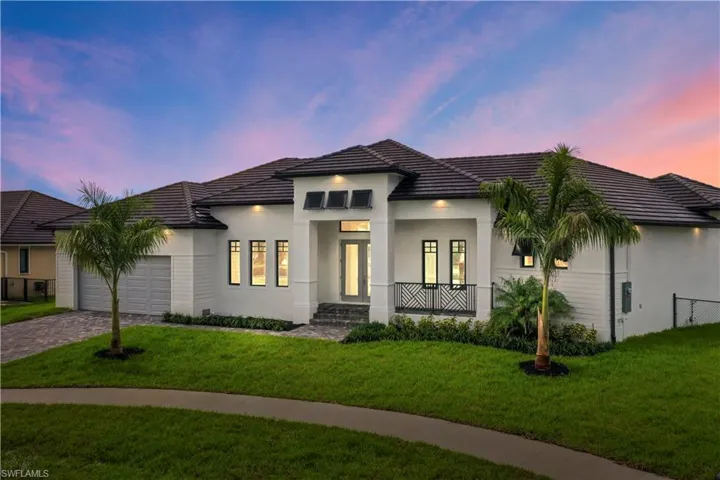 View of front of home with a garage and a yard