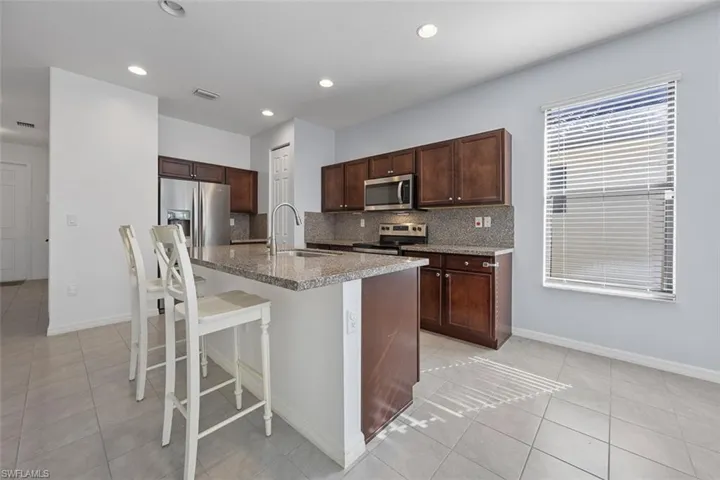 Kitchen featuring a sink, visible vents, appliances with stainless steel finishes, and decorative backsplash