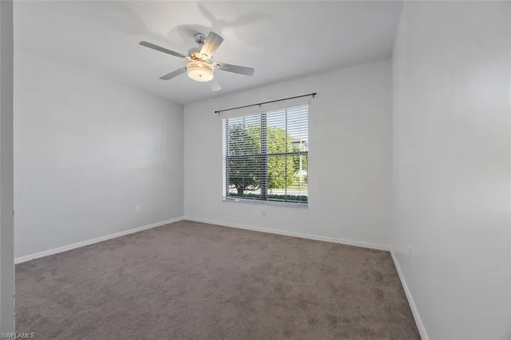 Empty room featuring carpet flooring, baseboards, and ceiling fan
