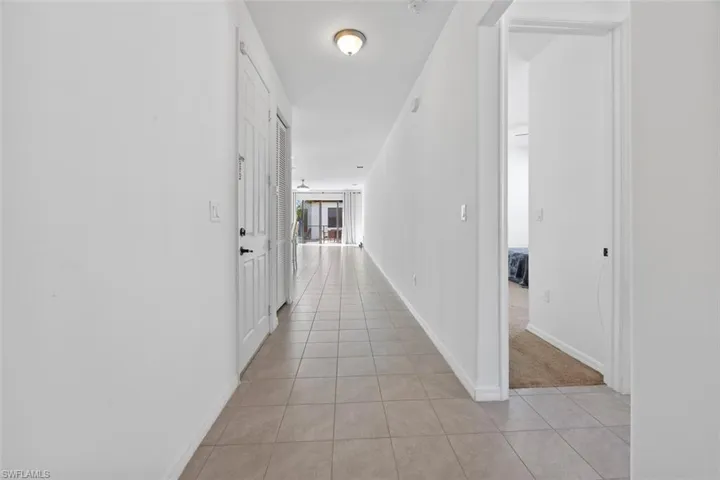 Hall with light tile patterned floors and baseboards