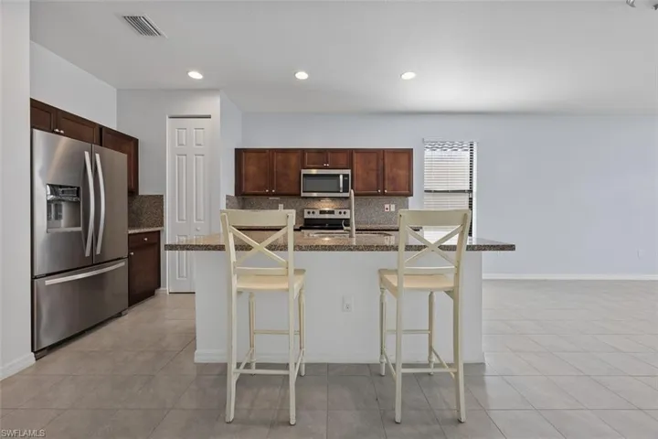 Kitchen with tasteful backsplash, visible vents, stainless steel appliances, and a sink