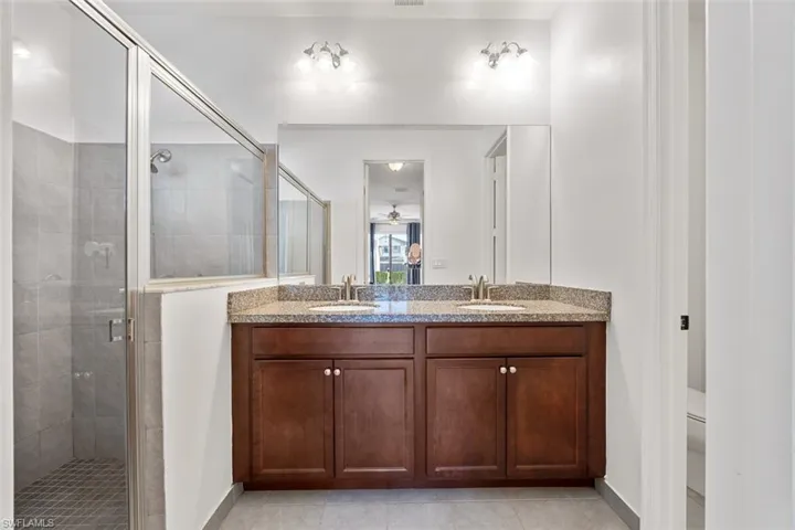 Bathroom featuring a sink, double vanity, and a shower stall