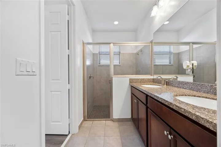 Full bathroom featuring tile patterned floors, a stall shower, and a sink