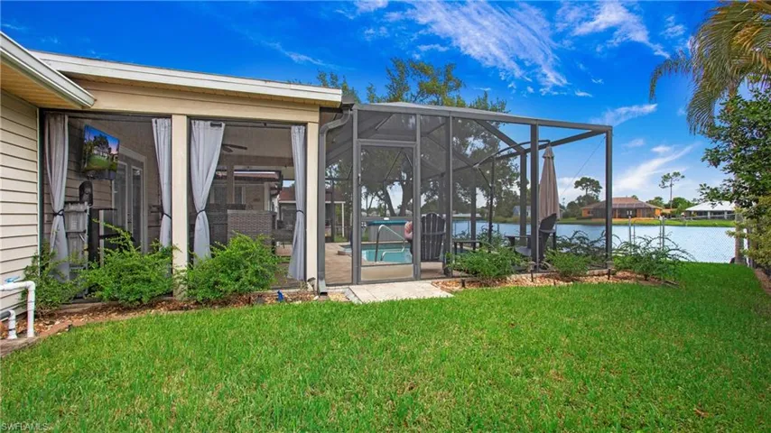 View of yard featuring glass enclosure and a water view