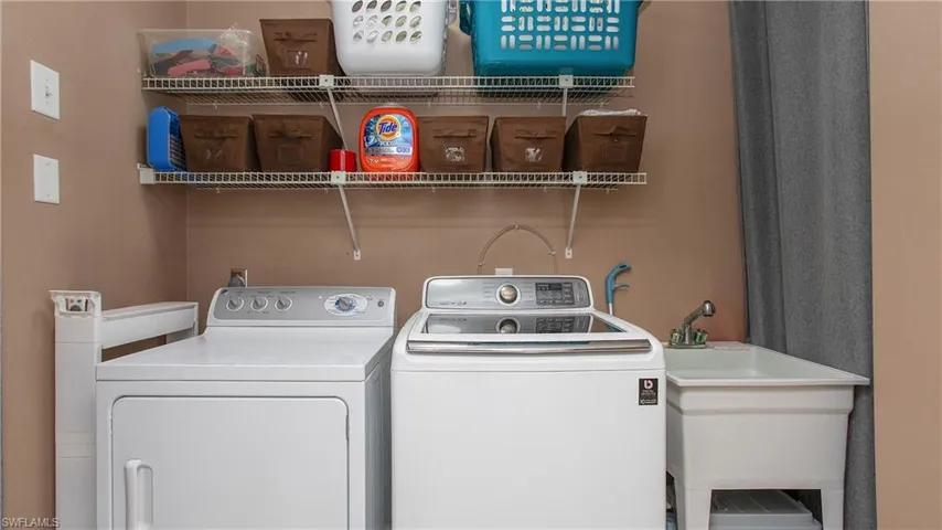 Clothes washing area featuring washer and clothes dryer and sink