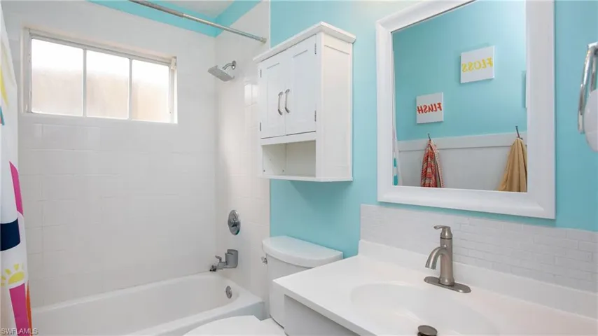 Full bathroom with vanity, toilet, and shower / bathtub combination with curtain