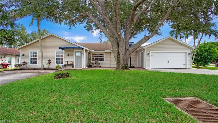 Single story home with a garage and a front lawn