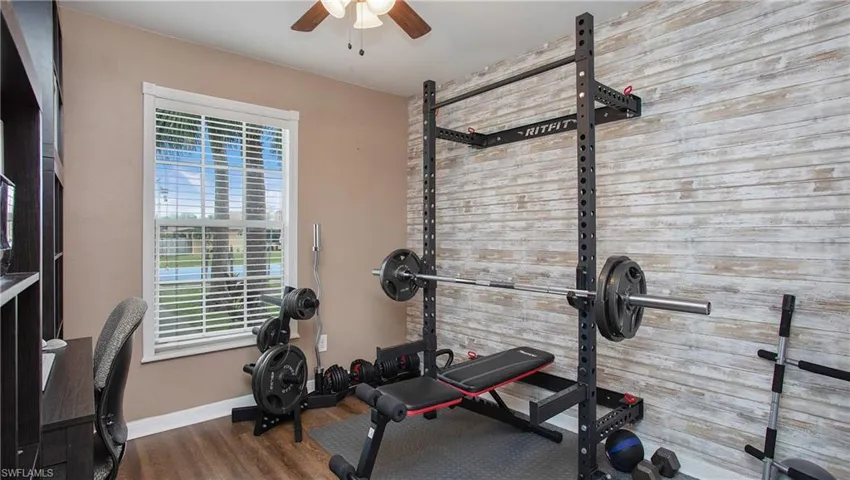Workout area with a healthy amount of sunlight, hardwood / wood-style floors, and ceiling fan