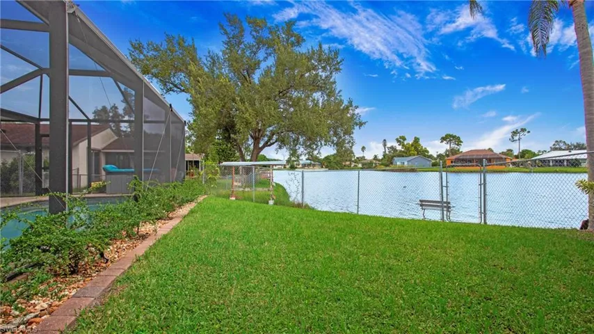 View of yard with glass enclosure and a water view