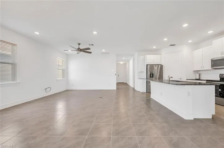 Kitchen with white cabinets, stainless steel appliances, recessed lighting, a kitchen island with sink, and open floor plan