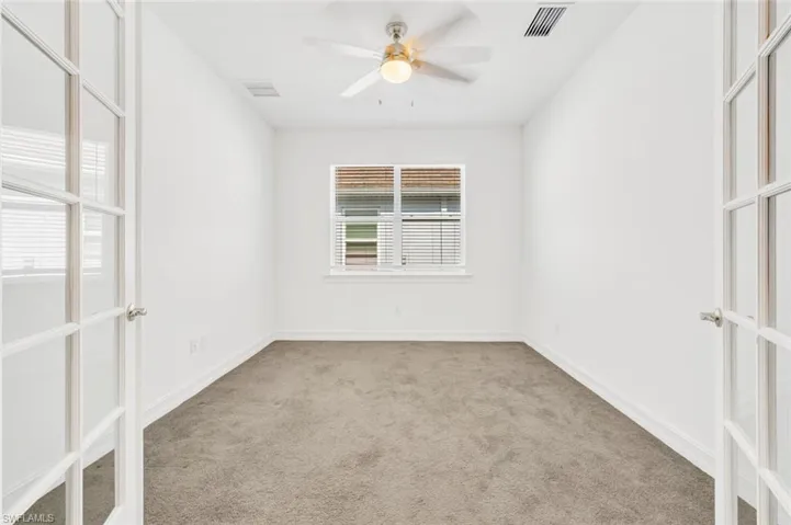 Empty room featuring light carpet and ceiling fan