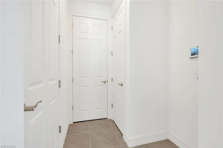 Hallway featuring light tile patterned flooring