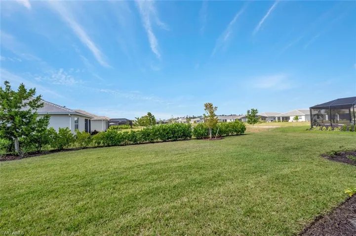View of green lawn with a sunroom and a residential view