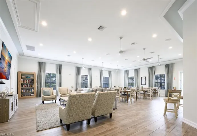 Living room featuring light wood-style flooring, a ceiling fan, ornamental molding, and recessed lighting