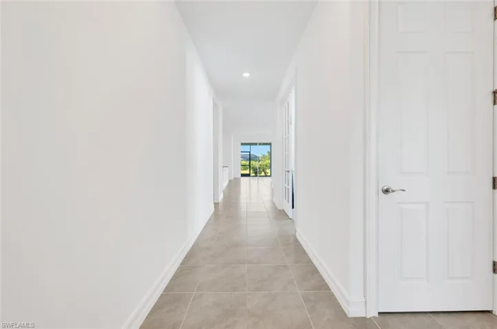 Hallway with recessed lighting and light tile patterned flooring