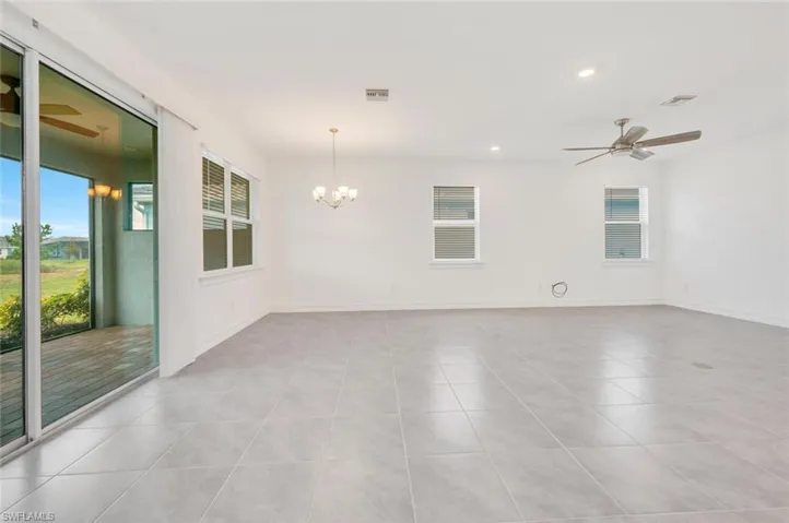 Spare room with ceiling fan, healthy amount of natural light, recessed lighting, and a chandelier