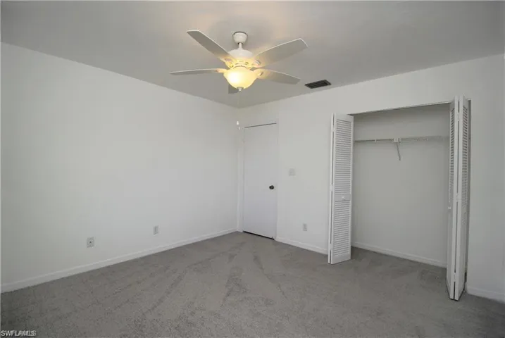 Unfurnished bedroom featuring a closet, ceiling fan, and carpet floors