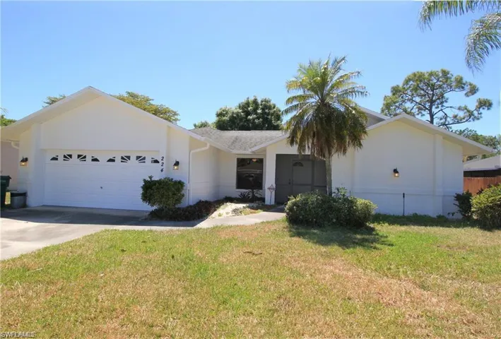 Ranch-style home featuring a garage and a front yard