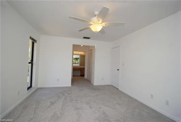 Carpeted empty room with ceiling fan
