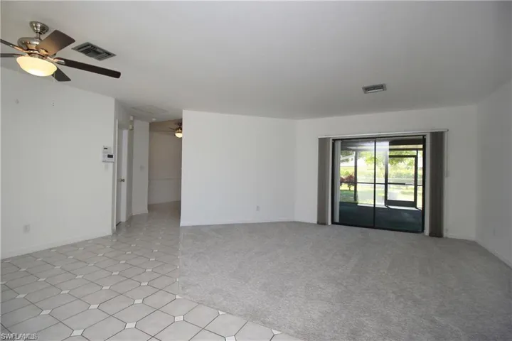 Carpeted spare room featuring ceiling fan