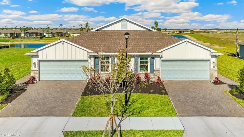 Model home. View of front facade with stone siding, board and batten siding, and a front lawn