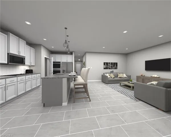 Kitchen with a breakfast bar area, backsplash, a center island with sink, white cabinetry, and appliances with stainless steel finishes