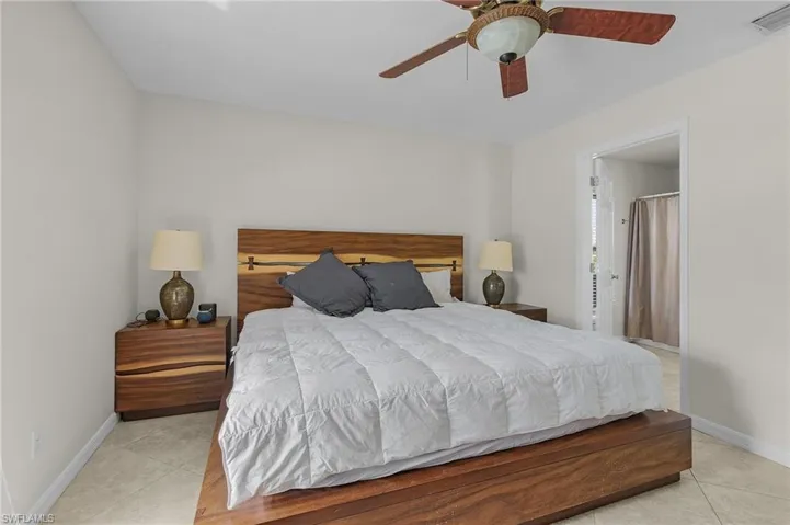 Bedroom with baseboards, a ceiling fan, visible vents, and light tile patterned flooring
