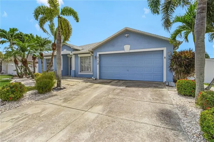 Ranch-style home featuring stucco siding, an attached garage, and driveway