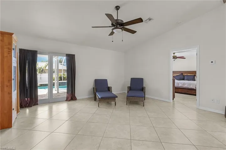 Unfurnished room with baseboards, vaulted ceiling, a ceiling fan, and light tile patterned floors