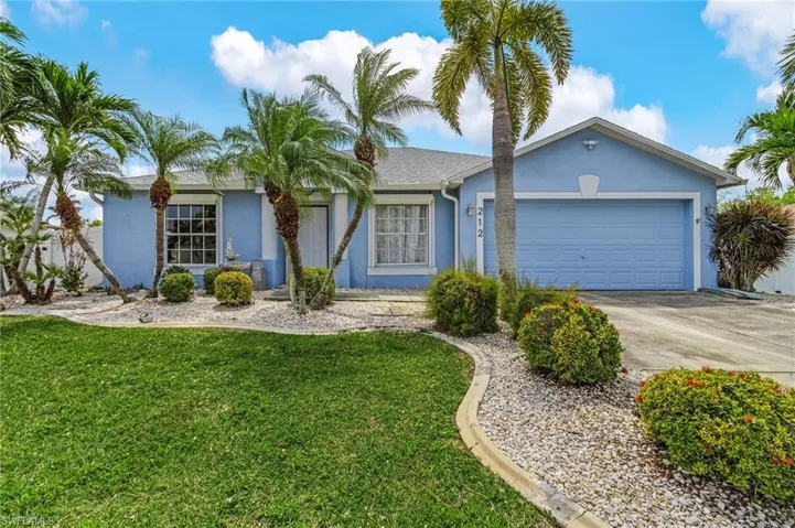 Single story home featuring an attached garage, concrete driveway, a front yard, and stucco siding