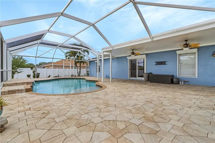 View of pool featuring a patio area, a fenced in pool, a ceiling fan, and glass enclosure