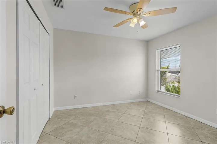 Unfurnished bedroom with baseboards, visible vents, a closet, and light tile patterned floors