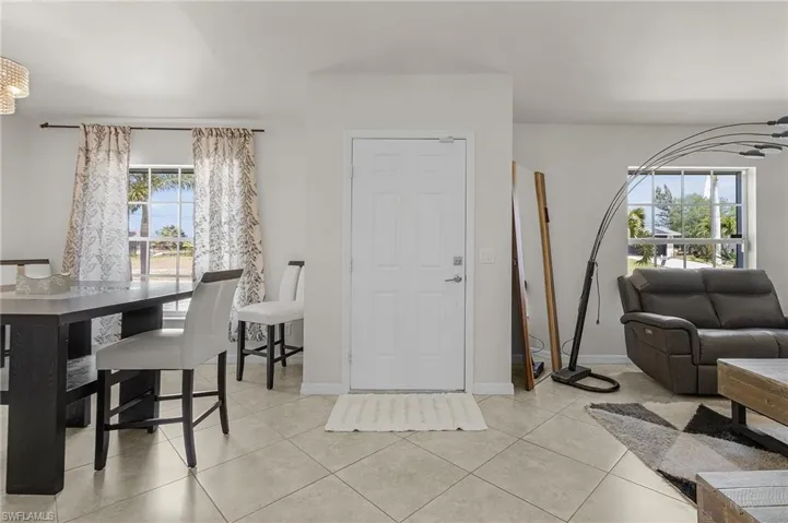 Living room with baseboards, a wealth of natural light, and light tile patterned floors
