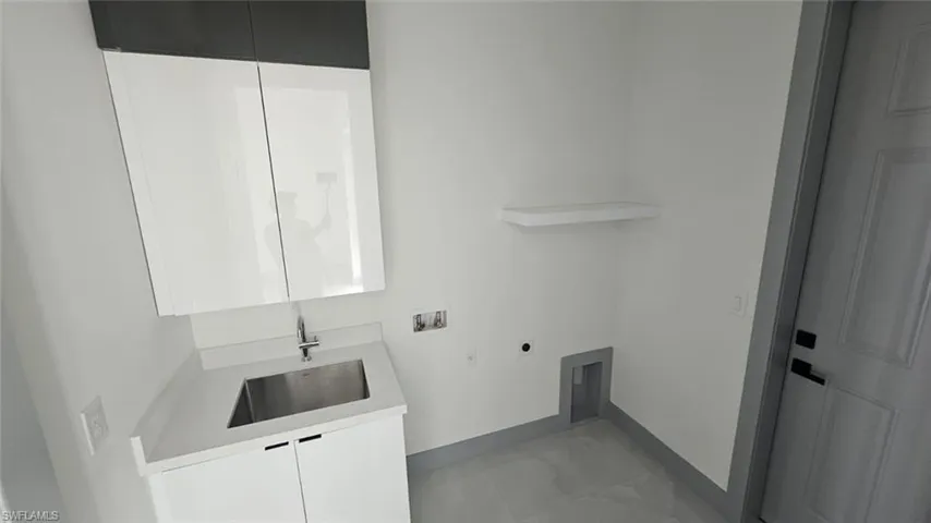 Clothes washing area with hookup for an electric dryer, cabinets, sink, and hookup for a washing machine