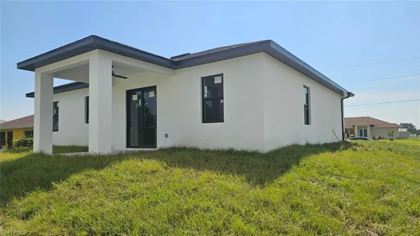 Back of property featuring a lawn