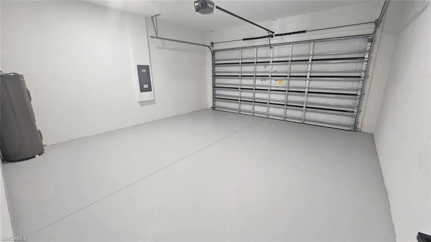 Garage featuring a garage door opener and electric panel