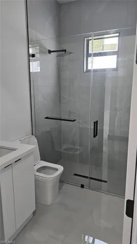 Bathroom with vanity, toilet, and a shower with door