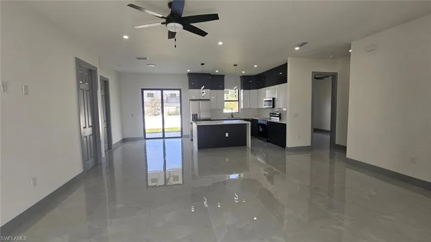 Kitchen featuring a center island, decorative light fixtures, stainless steel appliances, and ceiling fan