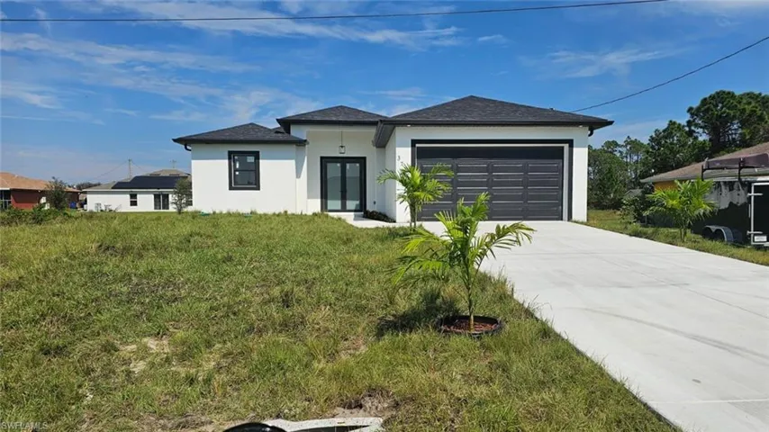 View of front facade featuring a front yard and a garage