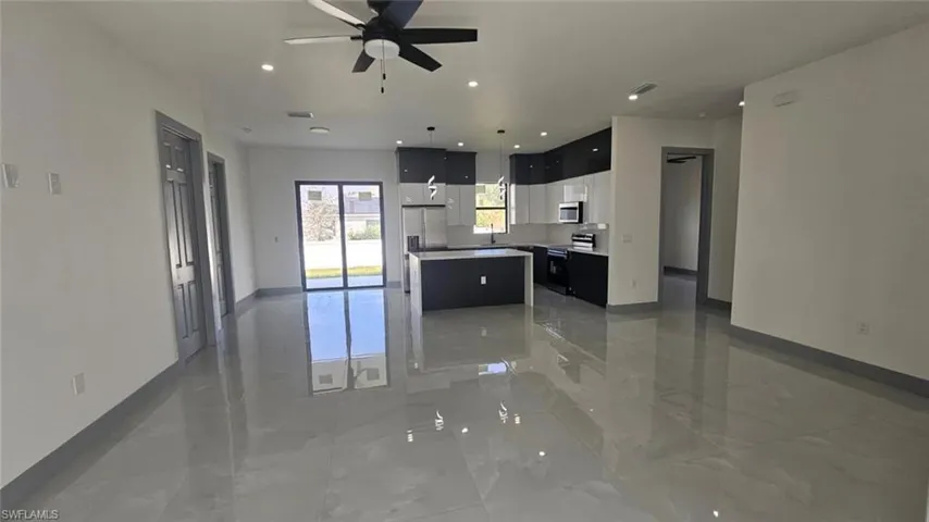 Kitchen with appliances with stainless steel finishes, a center island, and ceiling fan