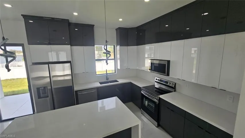 Kitchen with a center island, stainless steel appliances, and sink