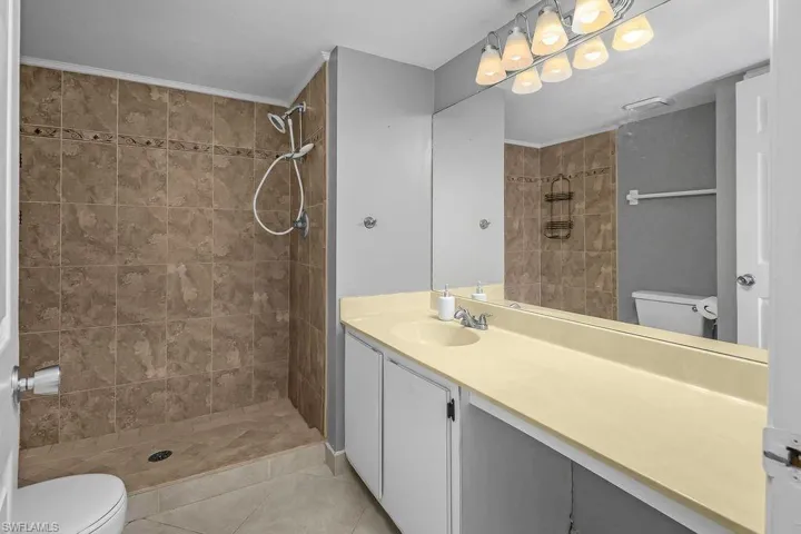 Full bath featuring a shower stall, vanity, and light tile patterned floors