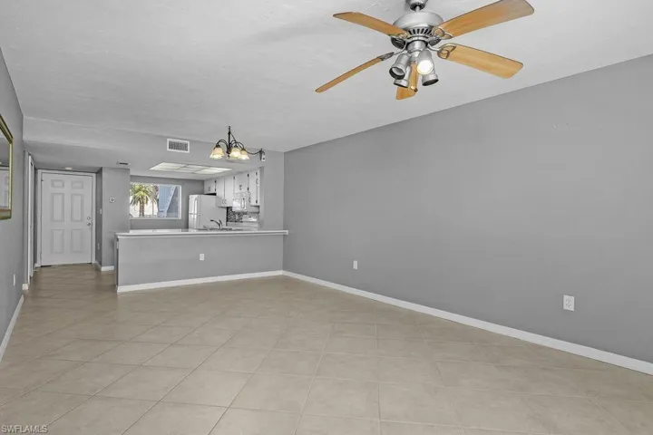 Unfurnished living room with a ceiling fan and a chandelier